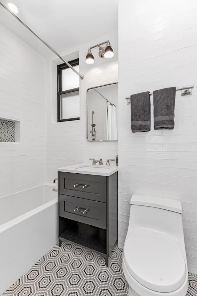 24 W 69th St Unit 9B, New York City, NY 10023 - full bathroom featuring tile walls, tile patterned floors, vanity, and toilet