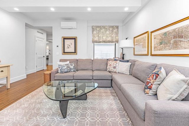 living room featuring a wall mounted air conditioner and light wood-type flooring