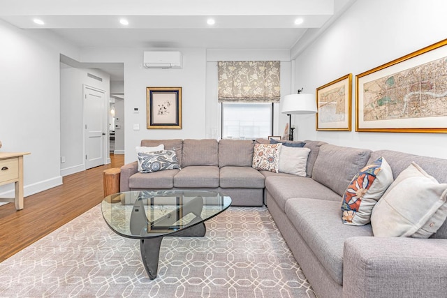 living area featuring recessed lighting, a wall unit AC, wood finished floors, and baseboards