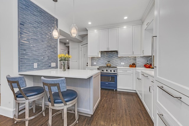24 W 69th St Unit 9B, New York City, NY 10023 - kitchen with white cabinets, backsplash, range with gas stovetop, and dark wood finished floors