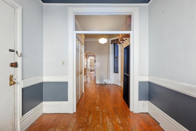 434 W 49th St Unit 1W, New York City, NY 10019 - corridor with arched walkways, wainscoting, radiator heating unit, and hardwood / wood-style floors