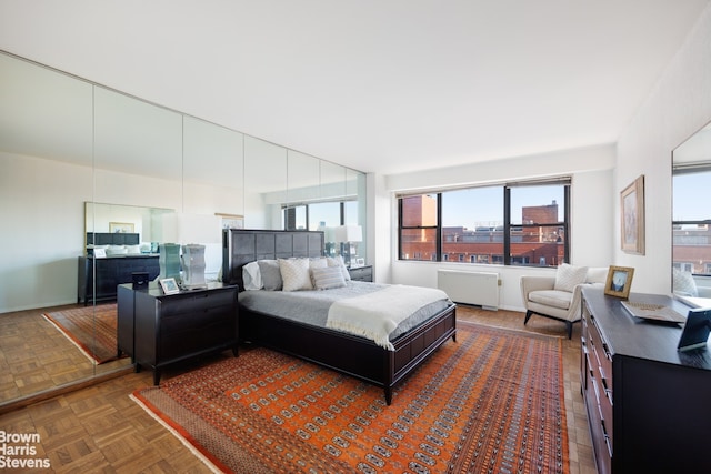bedroom featuring radiator heating unit and multiple windows