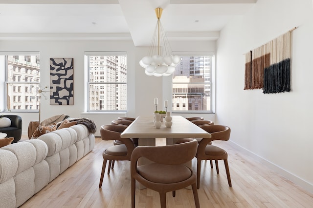 dining room with a notable chandelier, baseboards, and wood finished floors