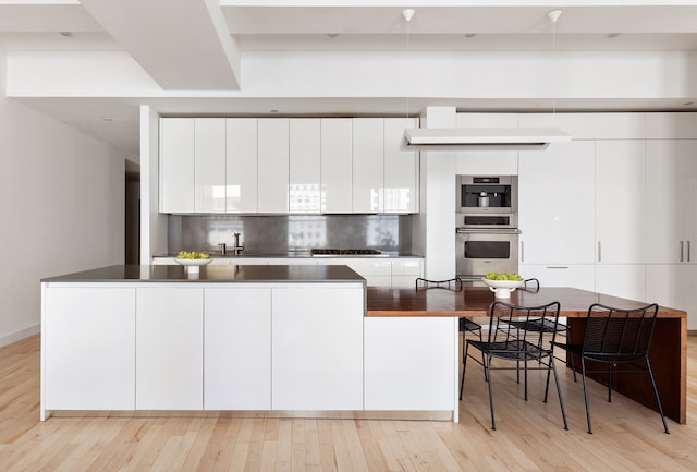 kitchen featuring dark countertops, modern cabinets, and white cabinetry