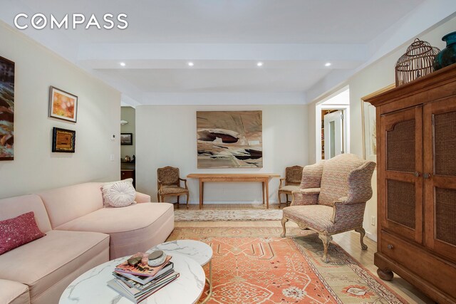 living room featuring light wood-style floors, beamed ceiling, and recessed lighting