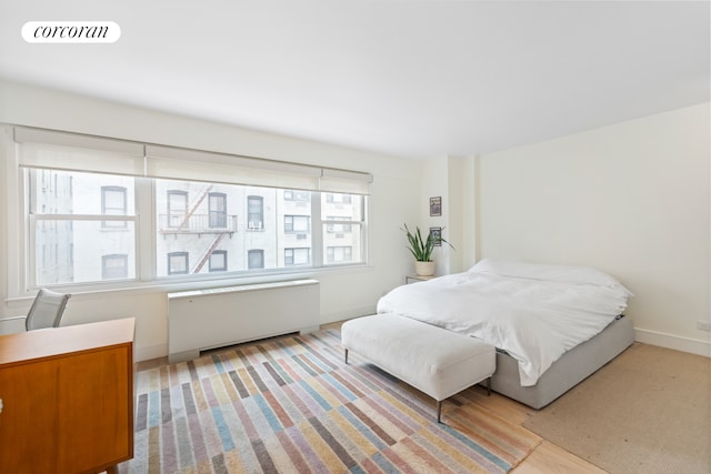 bedroom featuring radiator heating unit, visible vents, and baseboards