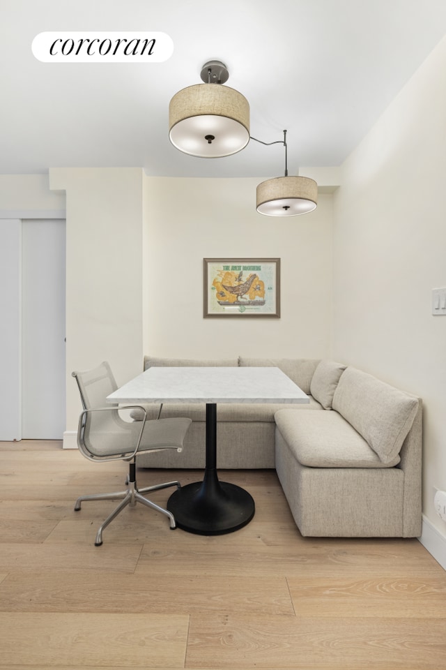 interior space with breakfast area, wood finished floors, and baseboards