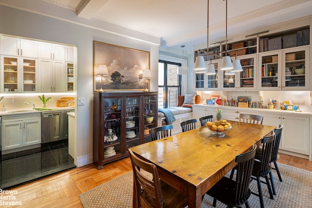 dining area with parquet floors, baseboards, and beam ceiling