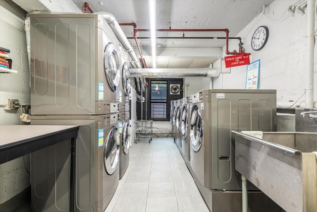 70 Park Ter W Unit E-23, New York City, NY 10034 - shared laundry with stacked washing machine and dryer, light tile patterned floors, and independent washer and dryer
