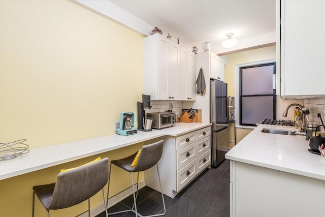 70 Park Ter W Unit E-23, New York City, NY 10034 - kitchen featuring a sink, freestanding refrigerator, white cabinets, and decorative backsplash
