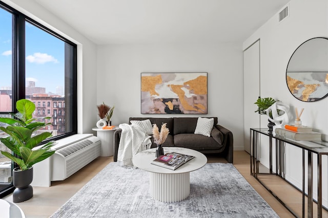 living area with a city view, visible vents, and wood finished floors