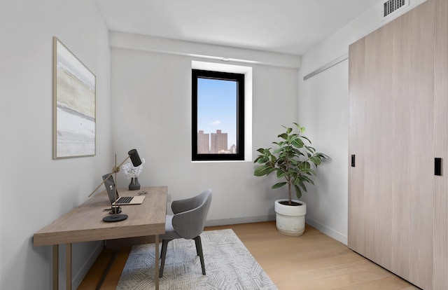 office featuring light wood-style floors, baseboards, and visible vents