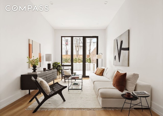 living area with baseboards and wood finished floors