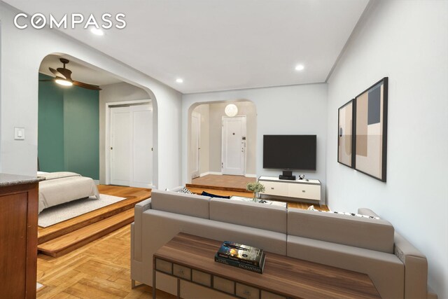 living room with arched walkways, ceiling fan, and recessed lighting