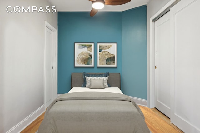 bedroom with ceiling fan, a closet, baseboards, and wood finished floors