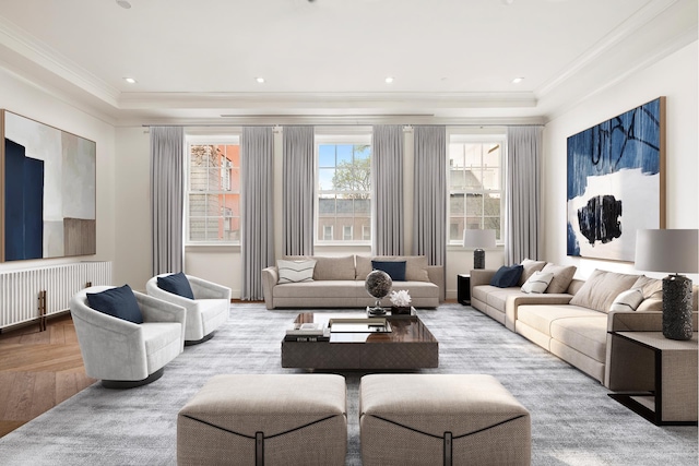 living area featuring crown molding, radiator heating unit, a raised ceiling, and wood finished floors