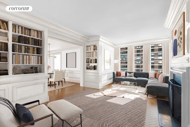 living room with a notable chandelier, a healthy amount of sunlight, dark wood-type flooring, and ornamental molding