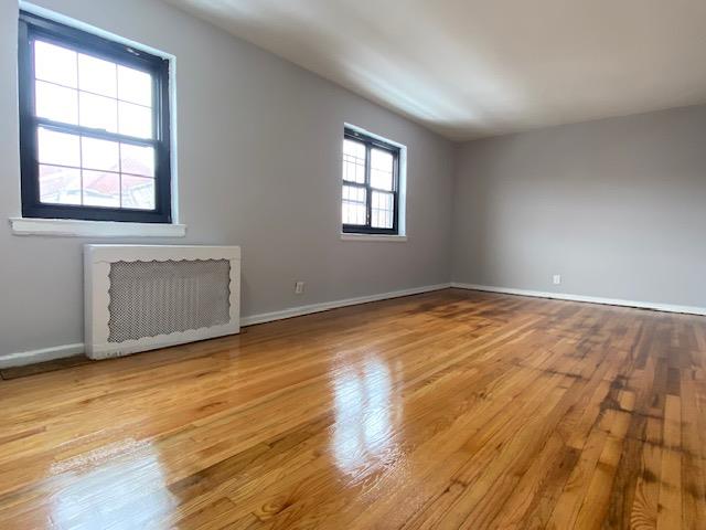 unfurnished room with light wood-type flooring and radiator