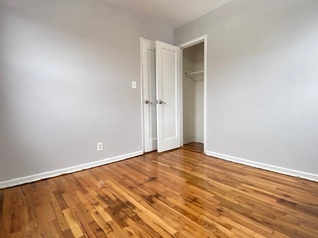 unfurnished bedroom with light hardwood / wood-style flooring and a closet