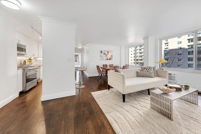 living area with ornamental molding, dark wood-style flooring, and baseboards