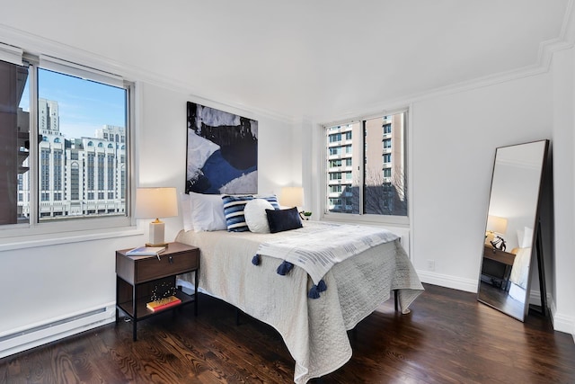 bedroom with a baseboard radiator, ornamental molding, and wood finished floors