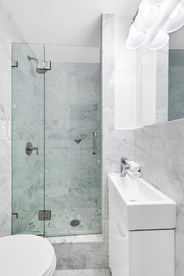 555 Main St Unit 602, New York City, NY 10044 - bathroom featuring a marble finish shower, vanity, and tile walls
