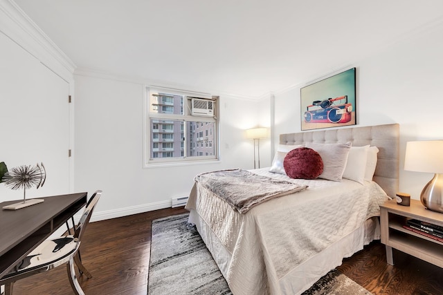 bedroom featuring baseboards, crown molding, a baseboard heating unit, and wood finished floors