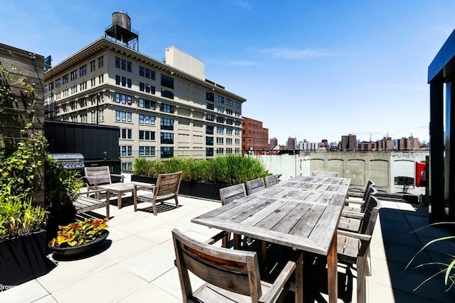 view of patio with a view of city, outdoor dining area, and a water view