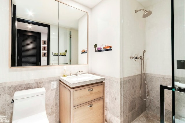 bathroom featuring toilet, a tile shower, tile walls, and vanity