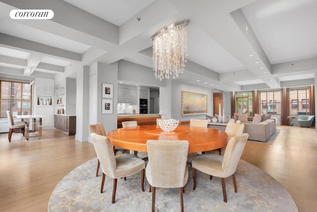 dining space featuring light wood finished floors, visible vents, coffered ceiling, and an inviting chandelier