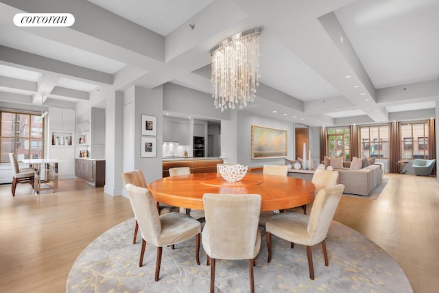 dining room with light wood finished floors, visible vents, coffered ceiling, and a chandelier