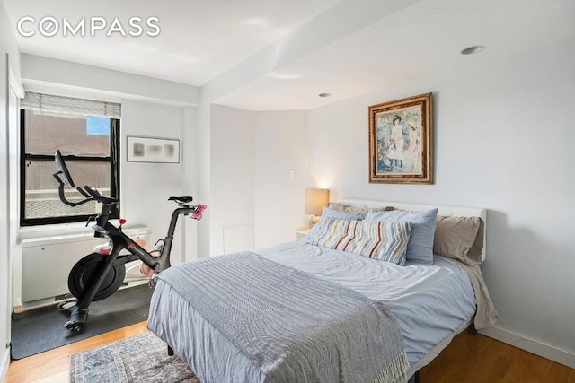 bedroom with baseboards and wood finished floors