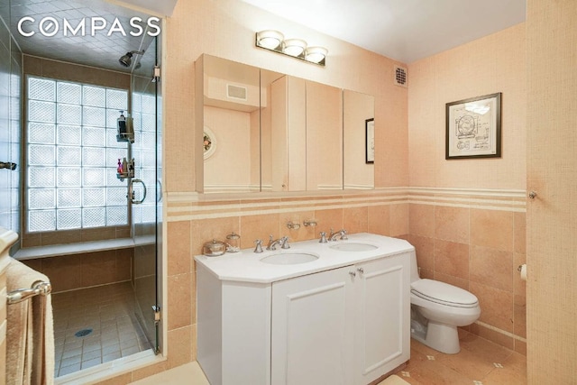 bathroom featuring a wealth of natural light, visible vents, tile walls, and a sink