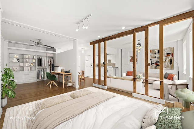 bedroom featuring track lighting, wood finished floors, and french doors