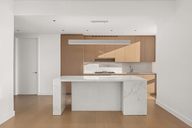 15 Hudson Yards Unit 38C, New York City, NY 10001 - kitchen with a sink, modern cabinets, baseboards, a center island, and light wood-style floors