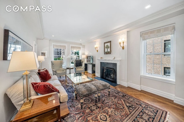 living room featuring a fireplace with flush hearth, baseboards, and crown molding