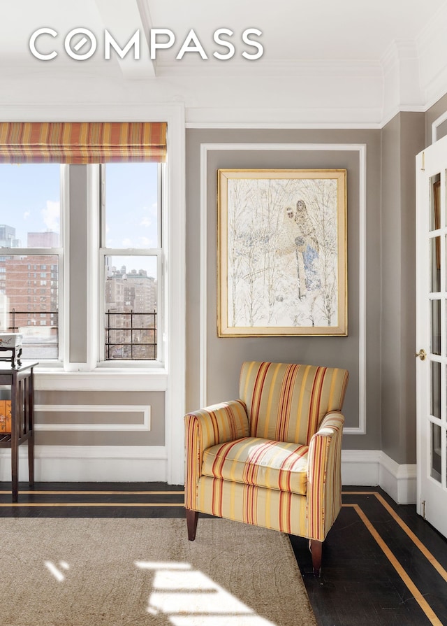 living area featuring a view of city, baseboards, and ornamental molding