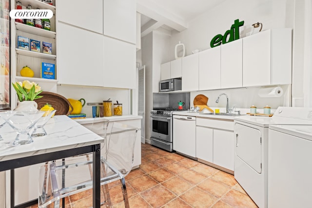 kitchen featuring white cabinets, appliances with stainless steel finishes, sink, and washing machine and clothes dryer