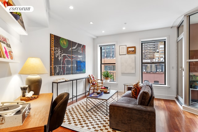 living area featuring wood finished floors, healthy amount of natural light, recessed lighting, and baseboards