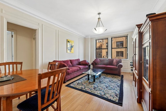 living room with light hardwood / wood-style flooring and crown molding