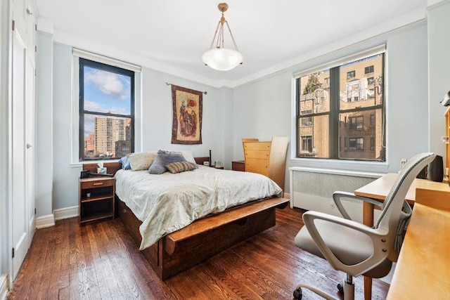 bedroom with dark wood-type flooring, radiator heating unit, and baseboards