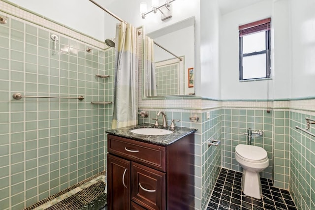 full bath with tile patterned flooring, toilet, a wainscoted wall, vanity, and tile walls