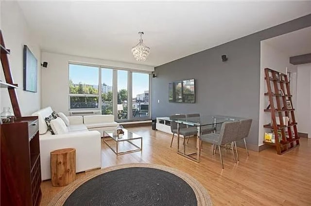 living room with a notable chandelier, wood finished floors, and floor to ceiling windows