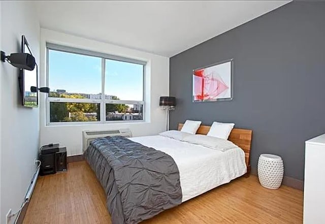 5-43 48th Ave Unit 3A, New York City, NY 11101 - bedroom featuring wood finished floors and a baseboard radiator