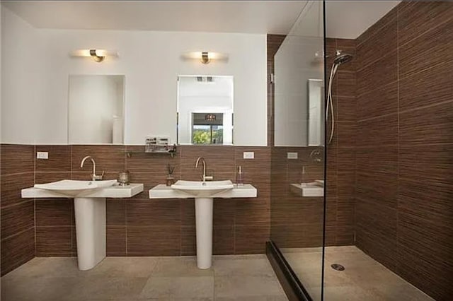 bathroom featuring walk in shower and tile walls