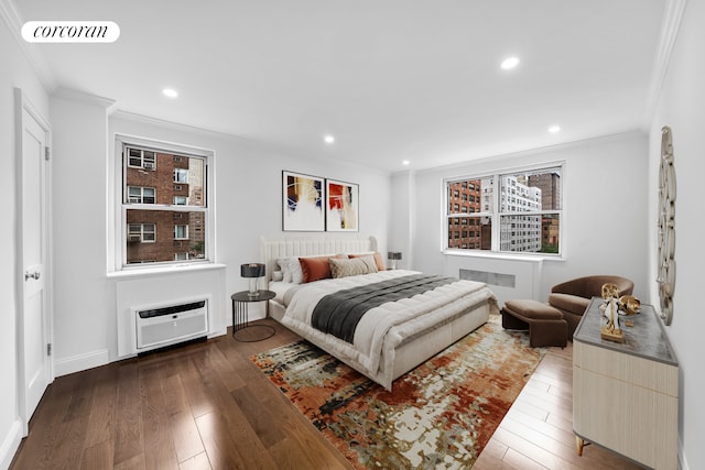 bedroom with wood-type flooring, visible vents, ornamental molding, and a wall mounted air conditioner
