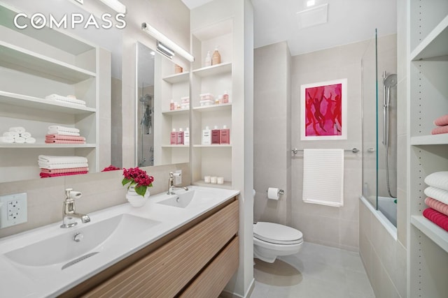 full bath featuring tiled shower / bath, double vanity, tile patterned flooring, and a sink