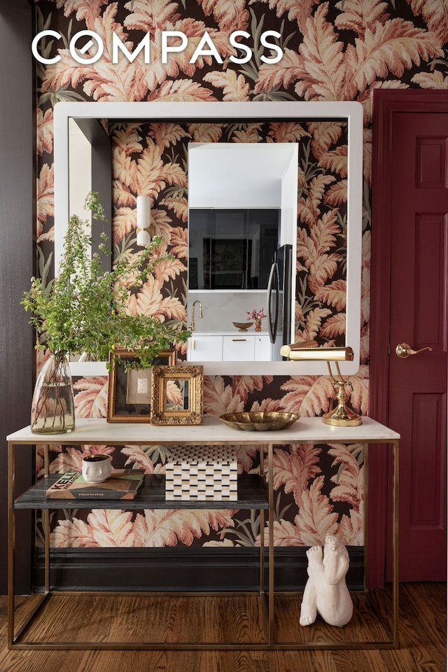 details with wallpapered walls, refrigerator, and wood finished floors