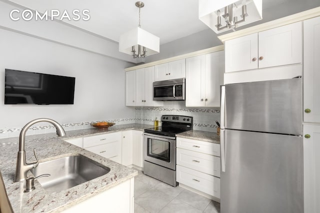 kitchen with backsplash, light stone countertops, stainless steel appliances, and a sink