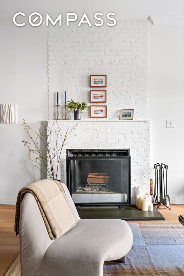 interior details with a fireplace, wood finished floors, and baseboards